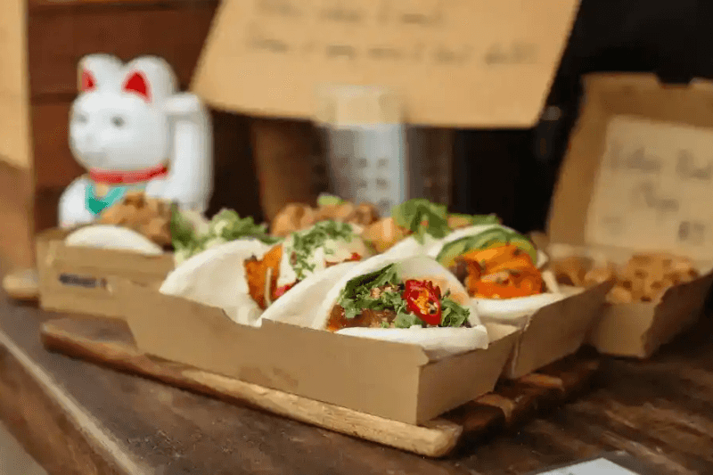 Bao buns végans au jack-fruit sur une assiette en bambou