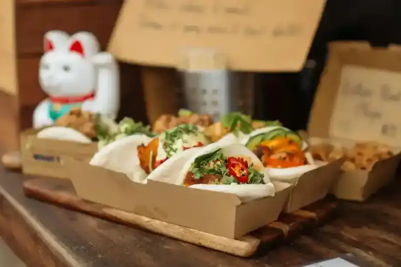 Bao buns végans au jack-fruit sur une assiette en bambou
