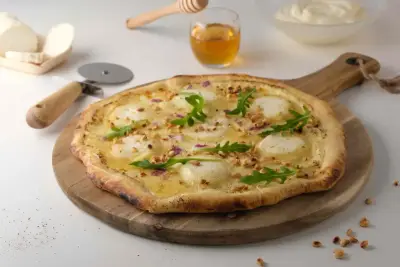 Pizza chèvre-miel maison avec thym frais sur pâte croustillante