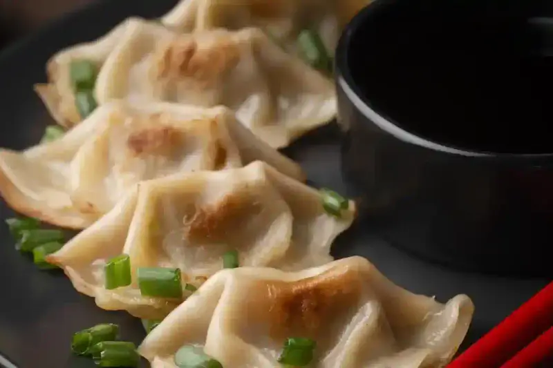 Ravioli chinois au bœuf servis avec sauce soja et coriandre