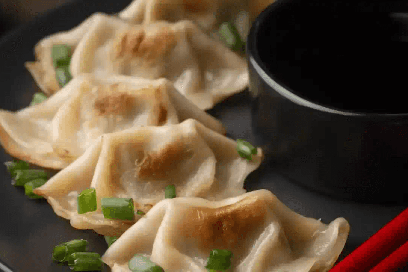 Ravioli chinois au bœuf servis avec sauce soja et coriandre